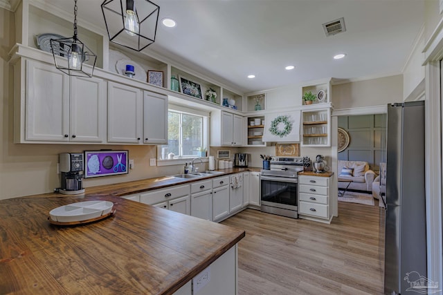 kitchen featuring visible vents, open shelves, a sink, stainless steel appliances, and butcher block counters