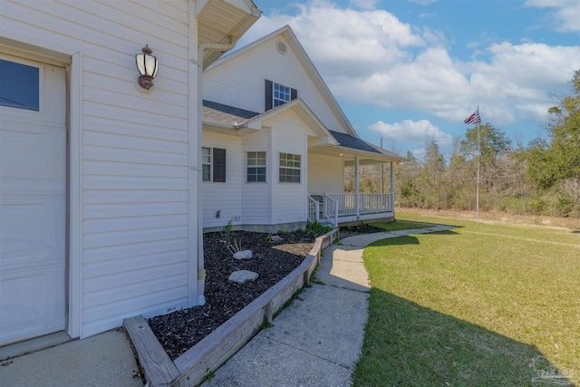 view of exterior entry featuring a porch, a yard, and roof with shingles