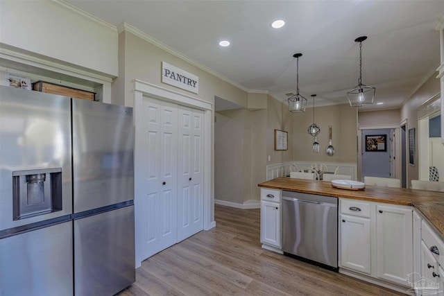 kitchen featuring light wood-type flooring, white cabinetry, appliances with stainless steel finishes, crown molding, and butcher block counters
