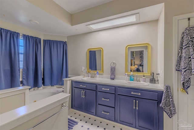 full bath with double vanity, tile patterned floors, a bath, and a sink