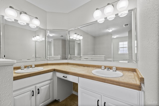 bathroom featuring double vanity, a sink, and visible vents