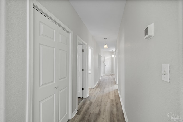 corridor featuring wood finished floors and baseboards