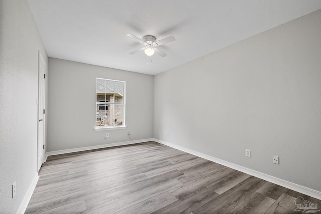 unfurnished room with a ceiling fan, baseboards, and wood finished floors