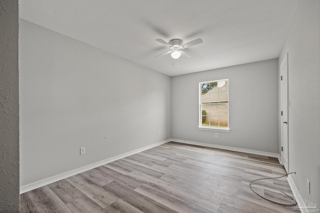 empty room featuring ceiling fan, baseboards, and wood finished floors