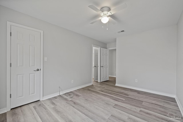 unfurnished bedroom with ceiling fan, light wood-style flooring, visible vents, and baseboards