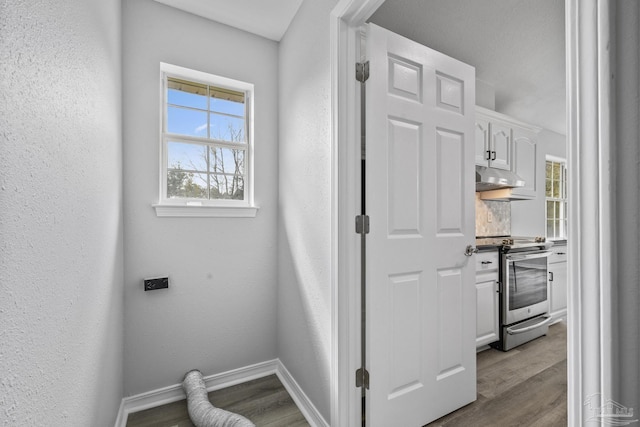 interior space with baseboards, wood finished floors, and a textured wall