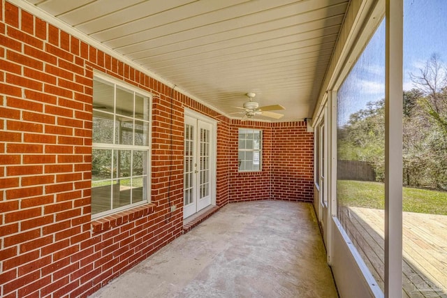 unfurnished sunroom with a ceiling fan and a healthy amount of sunlight