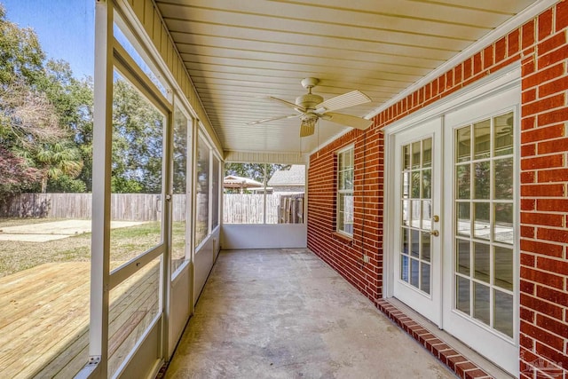 unfurnished sunroom featuring a ceiling fan