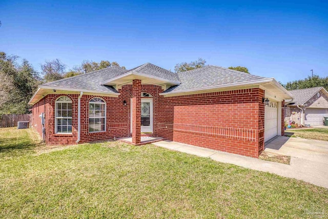 ranch-style home with brick siding, roof with shingles, an attached garage, a front yard, and driveway