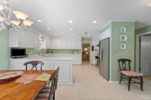 kitchen with kitchen peninsula, appliances with stainless steel finishes, and white cabinets