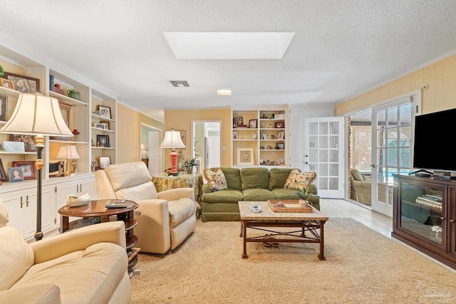 tiled living room featuring french doors, a textured ceiling, and a skylight