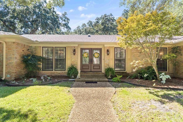 view of front of property featuring a front yard and french doors