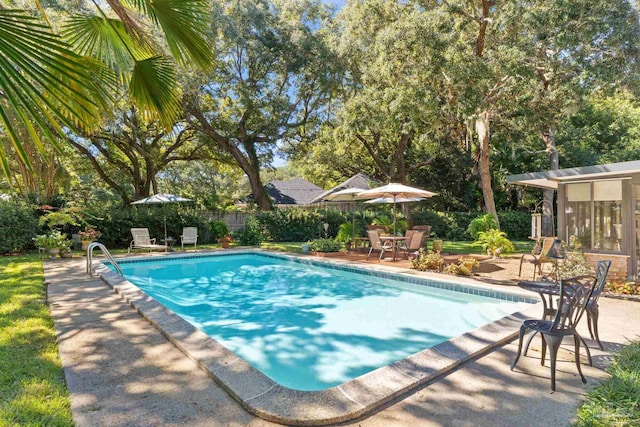 view of swimming pool featuring a patio area and a sunroom