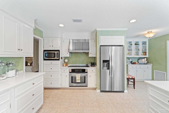 kitchen with white cabinets, stainless steel appliances, and wall chimney exhaust hood