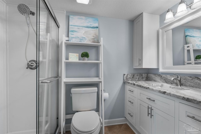 bathroom featuring a shower with door, a textured ceiling, toilet, vanity, and tile patterned floors