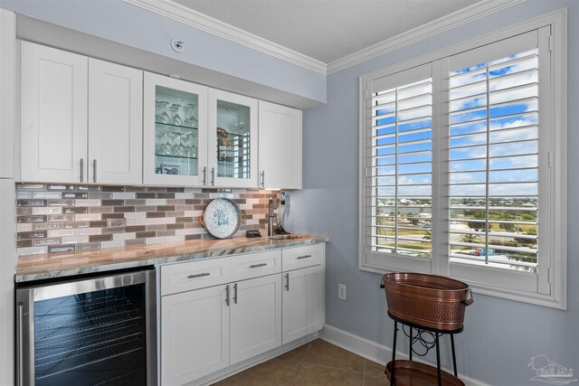 bar featuring white cabinets, tile patterned flooring, decorative backsplash, wine cooler, and ornamental molding