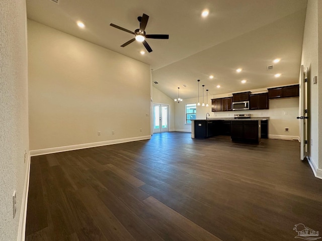 unfurnished living room featuring ceiling fan with notable chandelier, sink, dark wood-type flooring, and high vaulted ceiling