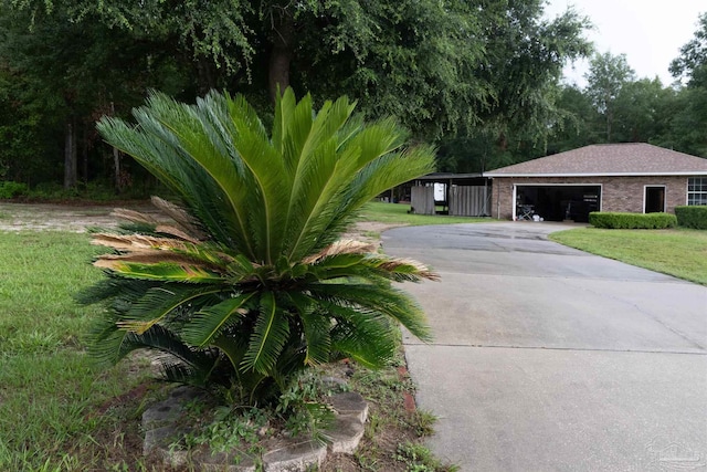 exterior space featuring a garage, a yard, and driveway