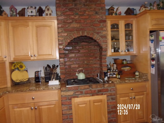 kitchen with stone counters, glass insert cabinets, and stainless steel appliances