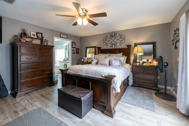 bedroom featuring ceiling fan, light wood-type flooring, ensuite bath, and baseboards