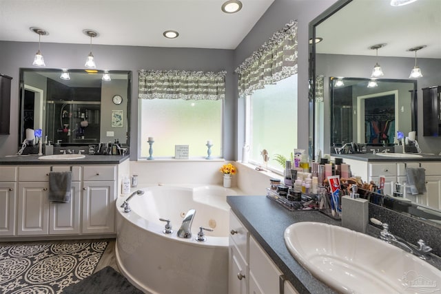 bathroom with a whirlpool tub, two vanities, a shower stall, and a sink