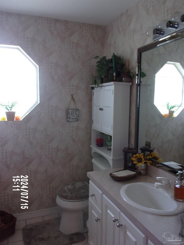 bathroom featuring a wealth of natural light, vanity, and wallpapered walls