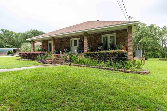 ranch-style home featuring cooling unit, a porch, a front lawn, brick siding, and french doors