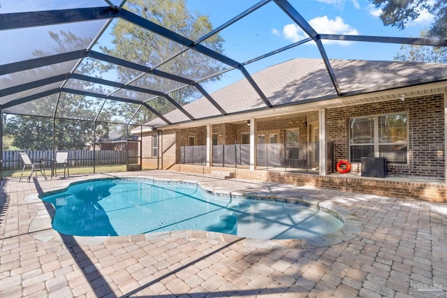 view of swimming pool with glass enclosure and a patio area