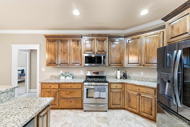 kitchen with light stone counters, ornamental molding, and appliances with stainless steel finishes