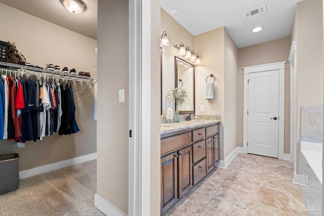 bathroom with a washtub and vanity