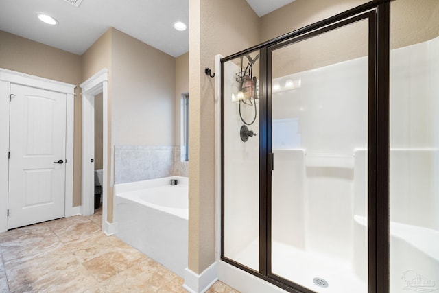 bathroom featuring toilet and independent shower and bath