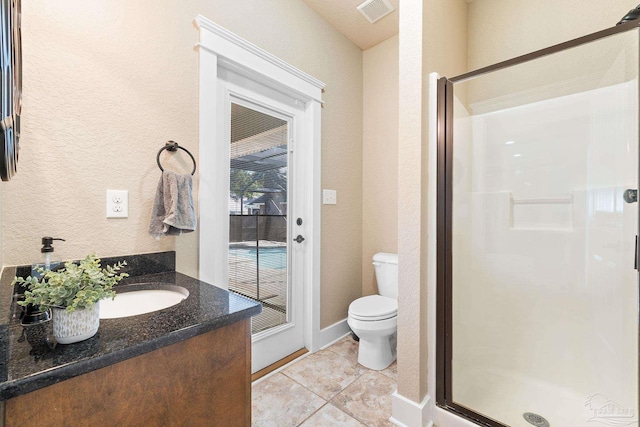 bathroom with tile patterned floors, vanity, toilet, and walk in shower