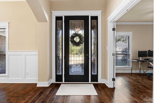 foyer entrance featuring crown molding and dark wood-type flooring