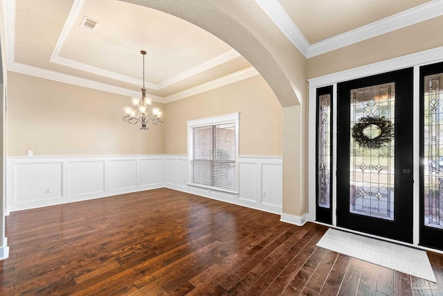 entryway with a chandelier, dark wood-type flooring, and a healthy amount of sunlight