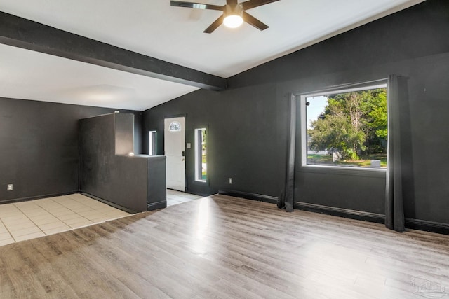 unfurnished room featuring ceiling fan, vaulted ceiling with beams, and light wood-type flooring