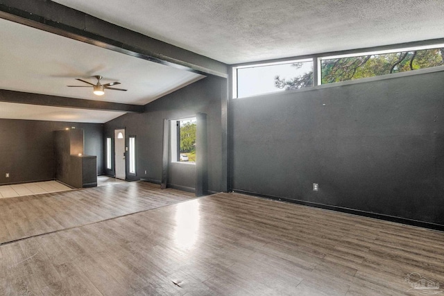 entrance foyer with a textured ceiling, vaulted ceiling with beams, light hardwood / wood-style floors, and ceiling fan