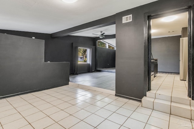 tiled empty room featuring ceiling fan, a textured ceiling, and lofted ceiling with beams