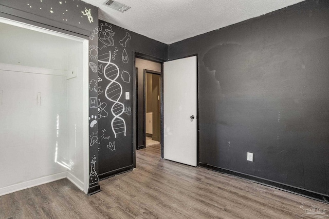 unfurnished bedroom with a textured ceiling and hardwood / wood-style floors