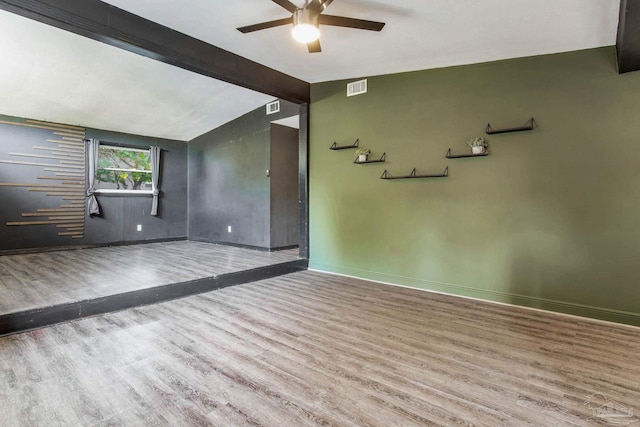 spare room featuring ceiling fan, lofted ceiling with beams, and hardwood / wood-style floors