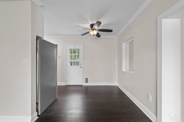 spare room featuring dark wood-type flooring, a textured ceiling, ceiling fan, and ornamental molding