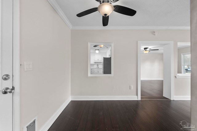 spare room with a textured ceiling, dark hardwood / wood-style flooring, and crown molding