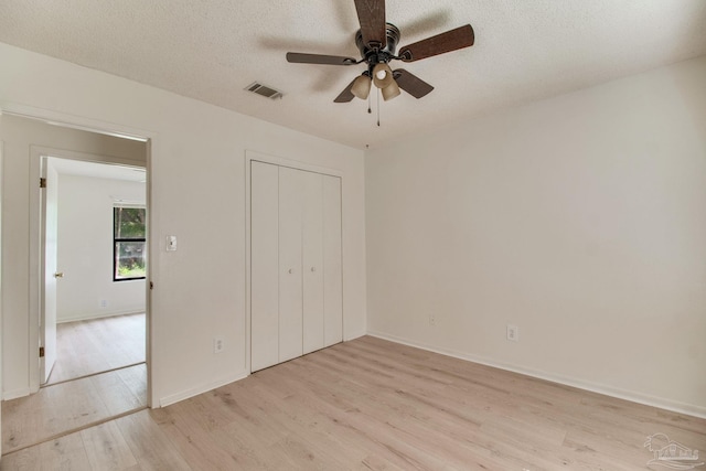 8500 Blue Jay Way, Pensacola, FL 32534 - unfurnished bedroom with light wood finished floors, a closet, a textured ceiling, baseboards, and a ceiling fan