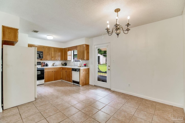 8500 Blue Jay Way, Pensacola, FL 32534 - kitchen with white appliances, light countertops, a chandelier, a textured ceiling, and light tile patterned floors