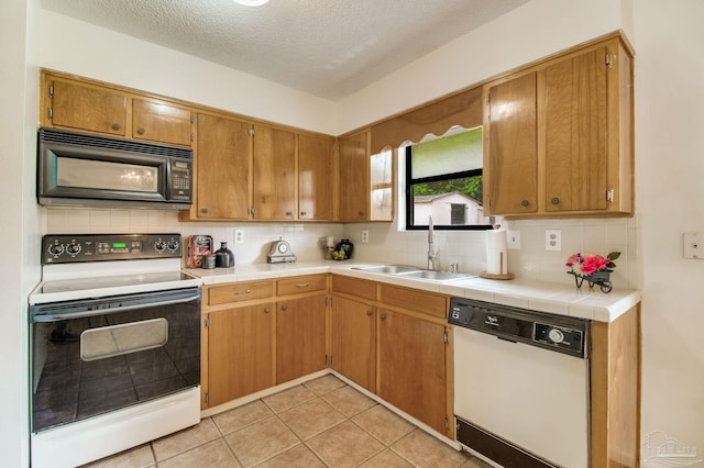 8500 Blue Jay Way, Pensacola, FL 32534 - kitchen with white appliances, a sink, tasteful backsplash, tile countertops, and a textured ceiling