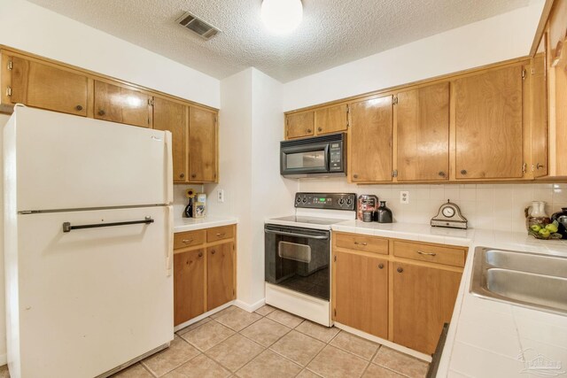 8500 Blue Jay Way, Pensacola, FL 32534 - kitchen featuring white appliances, tile counters, a sink, a textured ceiling, and backsplash