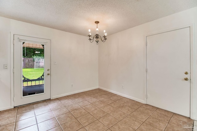 8500 Blue Jay Way, Pensacola, FL 32534 - unfurnished dining area featuring a chandelier, a textured ceiling, and light tile patterned floors