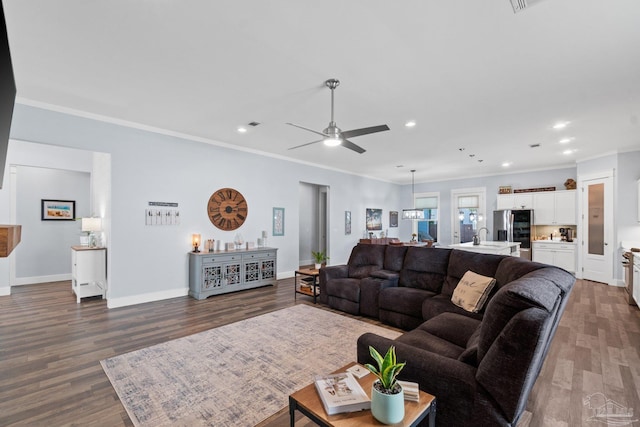 living room with crown molding, dark hardwood / wood-style floors, and ceiling fan