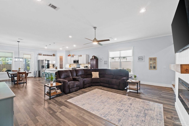 living room featuring ceiling fan, crown molding, and dark hardwood / wood-style flooring