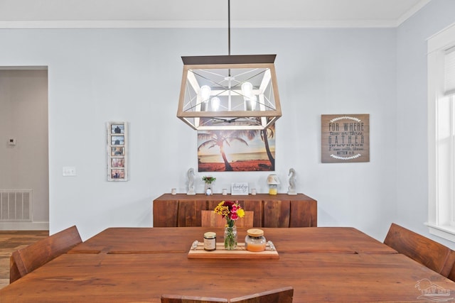 dining area with ornamental molding and hardwood / wood-style floors