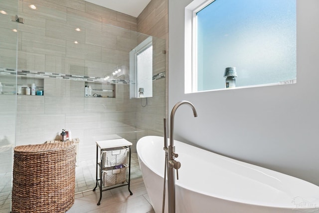 bathroom featuring separate shower and tub, tile patterned floors, and a wealth of natural light